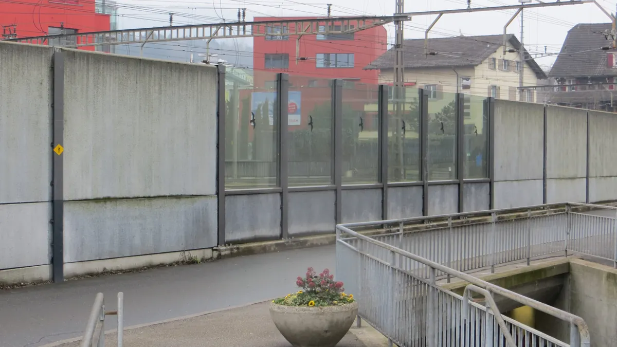 Noise barriers lining a railway line in Rotkreuz, Switzerland